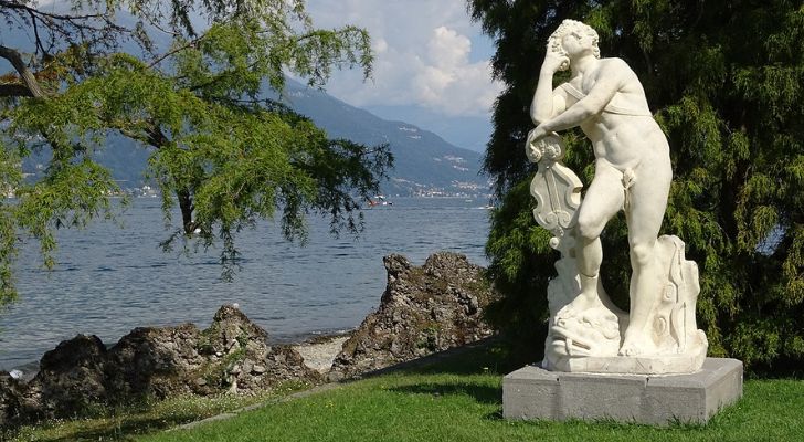 A statue of Apollo on the banks of a lake