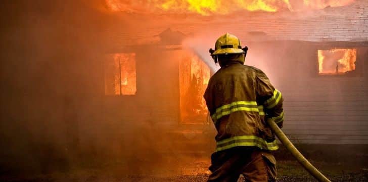 A firefighter putting out a building on fire