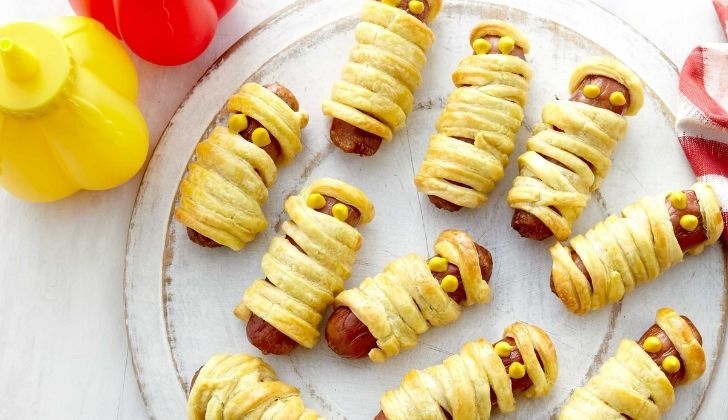 Scary looking mummified sausage rolls with eyes