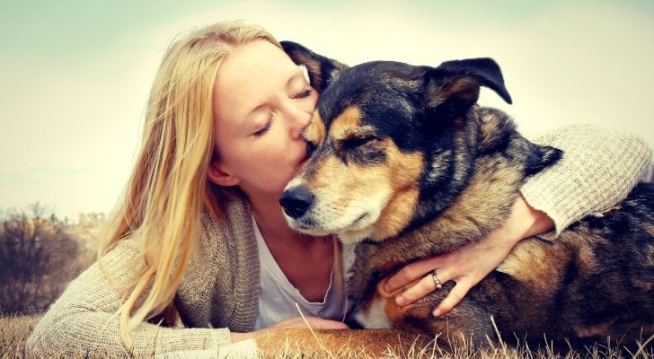 A German Shepherd being hugged and kissed