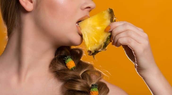 A woman eating pineapple