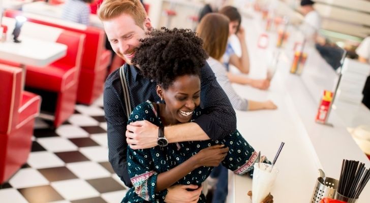 A young couple hugging at a diner