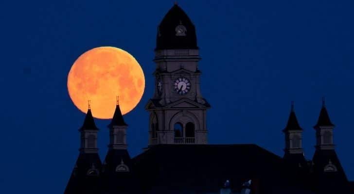 Bright worm moon in the sky behind a clocktower