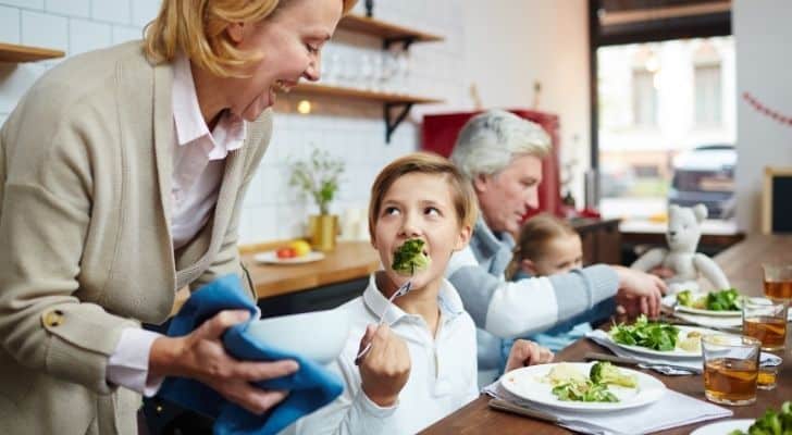 A family eating broccoli with their dinner