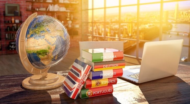 A globe, laptop and several books on languages