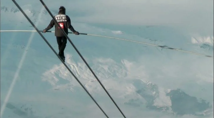 Freddy Rock walking a zip line that's incredibly high