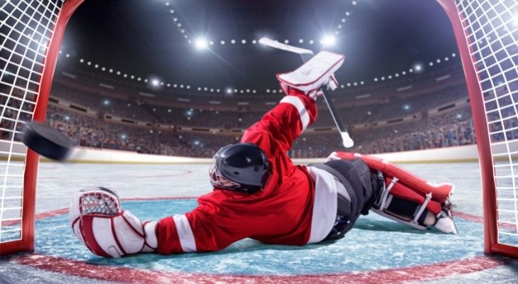 Goalie trying to stop a puck.