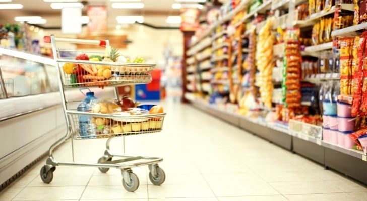 A cart full of groceries inside a supermarket.