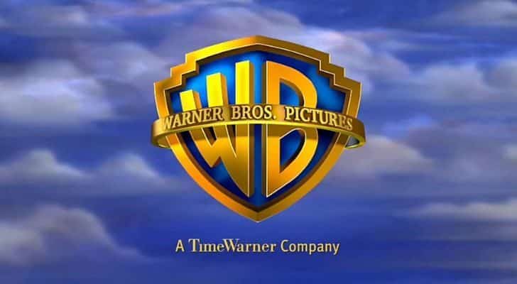 The Warner Bros logo as a golden W and B against a cloudy sky