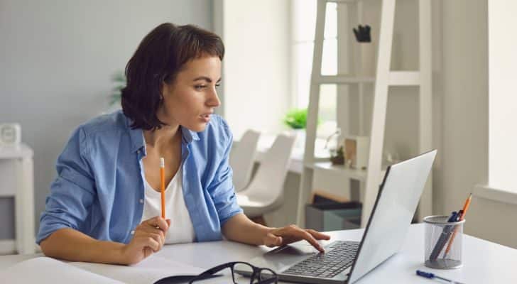 A woman at a desk learning something using her laptop