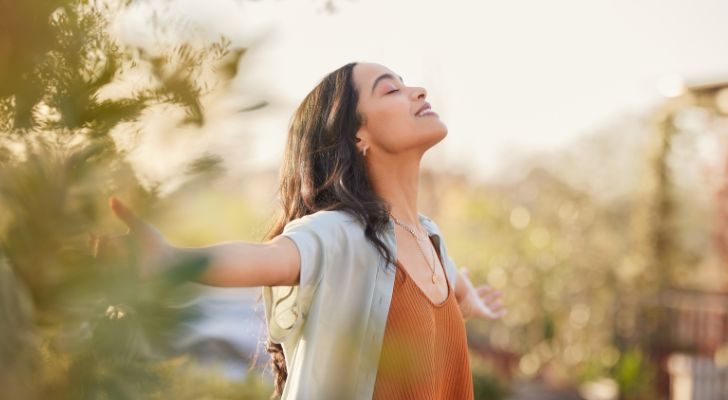 A woman in nature relaxing and smiling