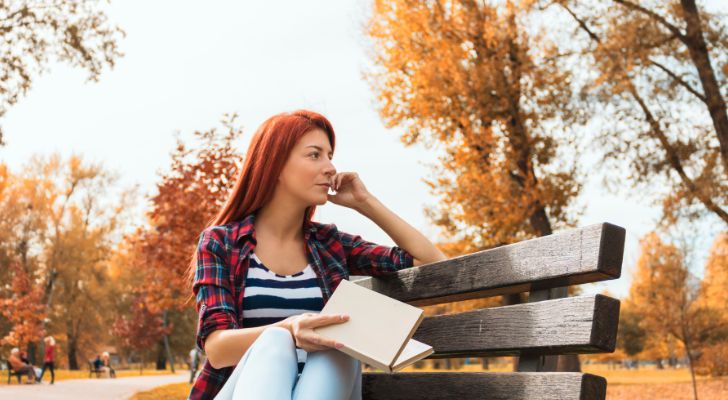 A woman sitting on a bench, looking off into the distance