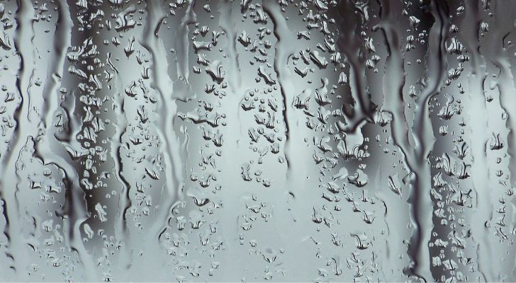 A pane of glass with rain trickling down it