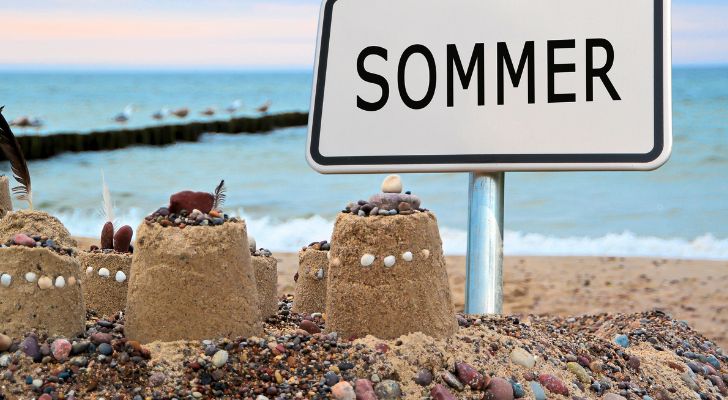 A sand castle built next to a sign that reads "Sommer"