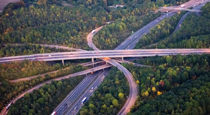 A multilane interchange on the M25 motorway surrounded by forest