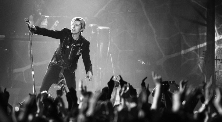 David Bowie on stage in front of a crowd of fans