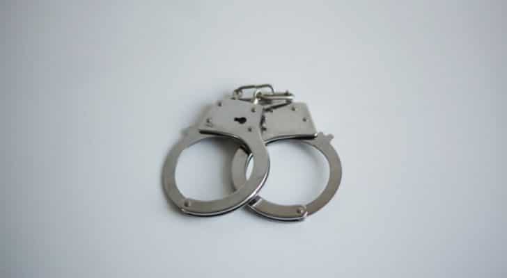 A pair of metal handcuffs placed on a table