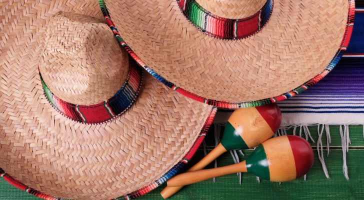 A pair of maracas is laid down next to two sombreros