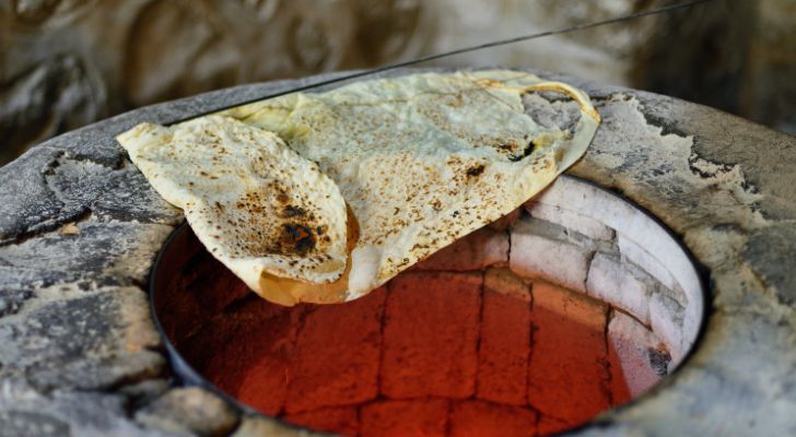 Some Armenian lavash bread is being warmed on the edge of a bread oven