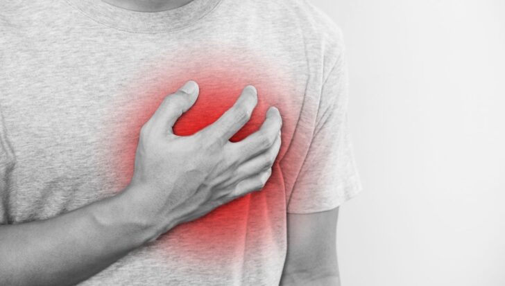 Person clutching their chest with a red highlight over the heart area, indicating potential heart discomfort