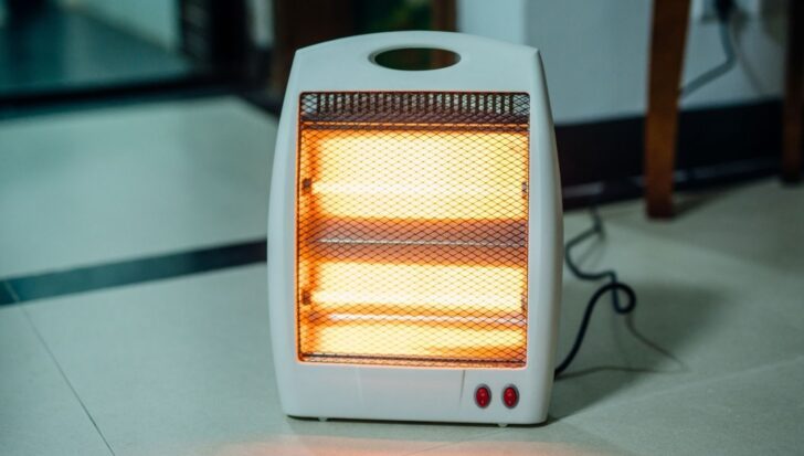 Portable heater on a tiled floor, lit and in operation