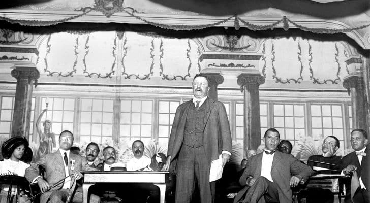 Theodore Roosevelt addressing a crowd from a stage