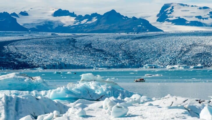 Icy landscape with glaciers in Iceland, featuring a small boat on the water