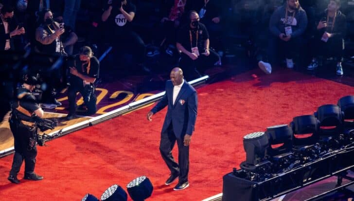 Michael Jordan walking on a red carpet surrounded by photographers and onlookers