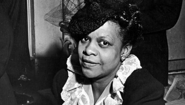 Portrait of Eunice Carter wearing a formal outfit and a hat