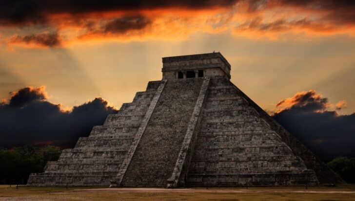 Mayan pyramid at Chichen Itza sunset with dramatic clouds in the sky