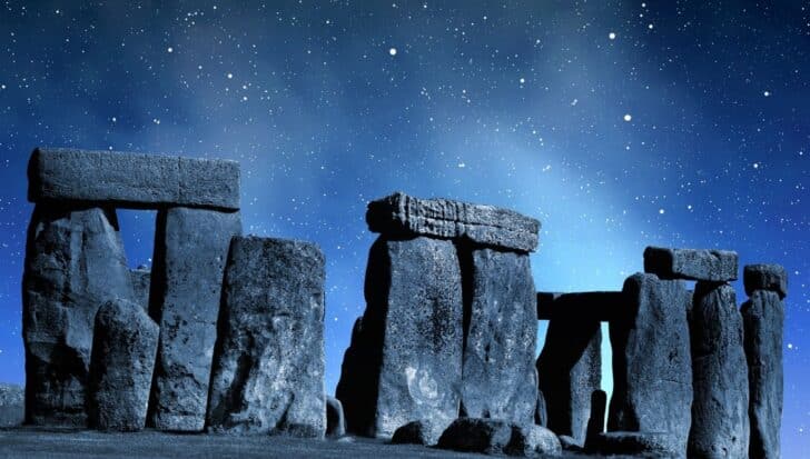 Stonehenge under a starry night sky, showcasing its ancient structure with massive stones