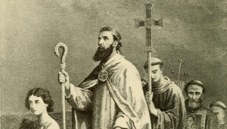 Illustration depicting Saint Patrick with a group of followers, holding a staff and cross