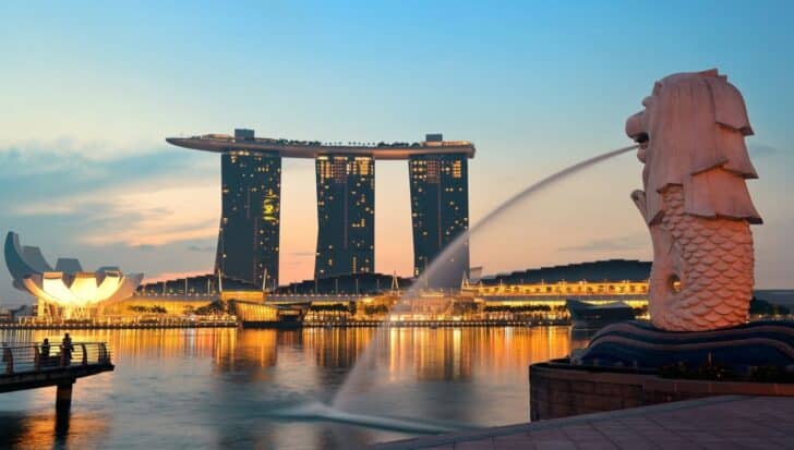 The Singapore skyline at dusk with the Marina Bay Sands and the Merlion statue near the water