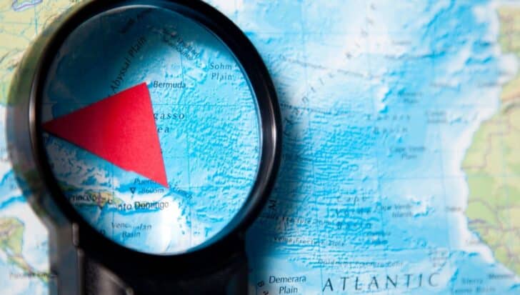 Magnifying glass highlighting the Bermuda Triangle on a map