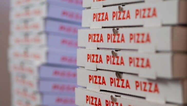Stacks of pizza boxes with the word 'PIZZA' printed in red