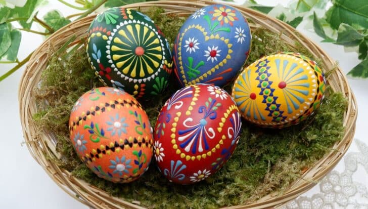 A basket filled with intricately decorated Easter eggs featuring colorful patterns and designs