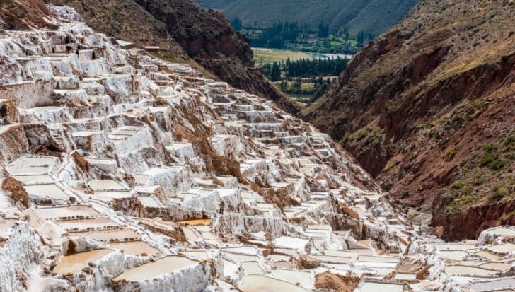 Terraced salt pans in Peru against a mountainous backdrop, highlighting the traditional method of salt forming