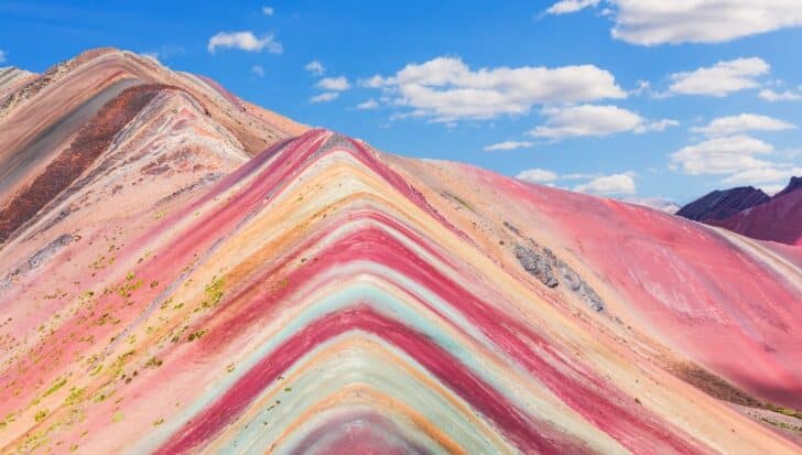 Colorful mountain with rainbow-like stripes under a blue sky in Peru