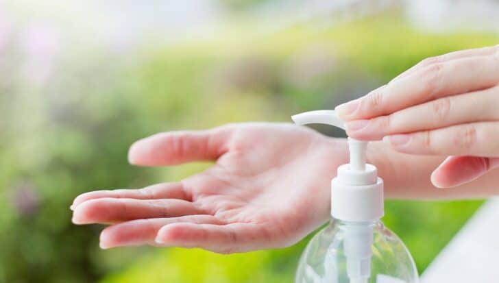 Hands using a pump bottle of soap, focusing on hygiene and cleanliness