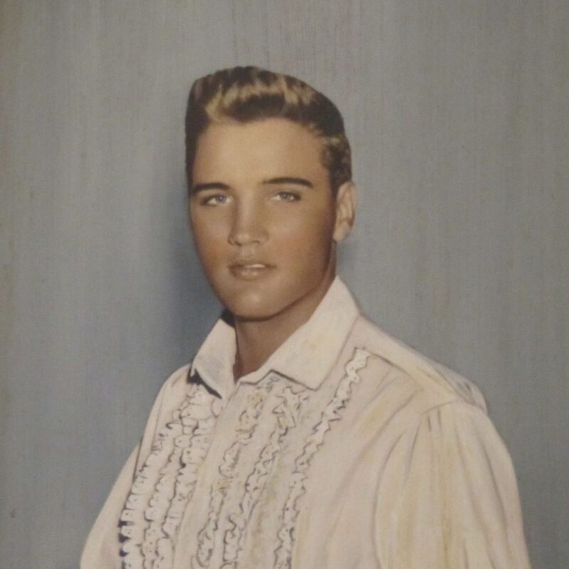 Elvis Presley with his natural blond hair in a ruffled, light-colored shirt