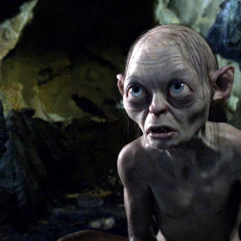 Gollum sitting in a dark cave with a fearful expression
