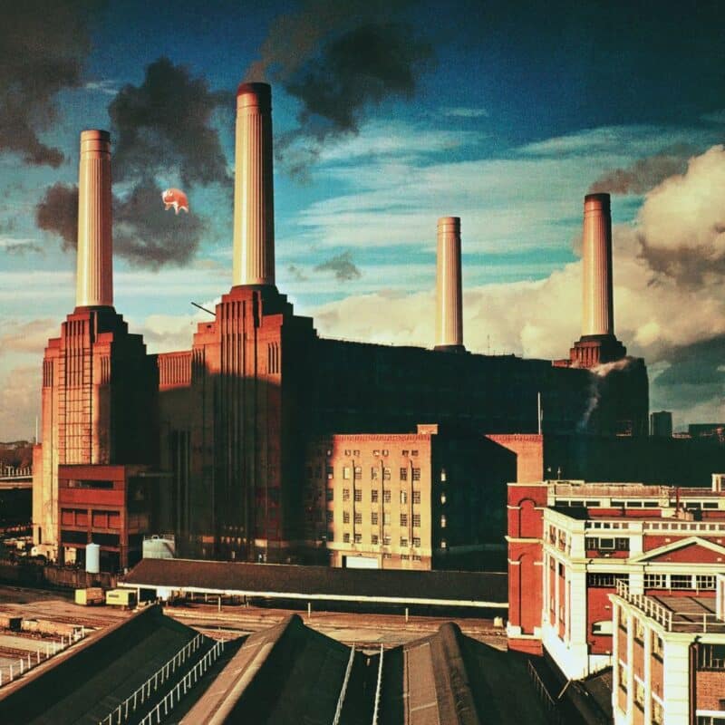 The Battersea Power Station with an inflatable pig floating nearby under a cloudy sky