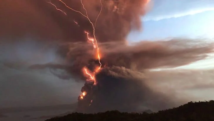 Volcanic eruption with dark ash clouds and visible lightning