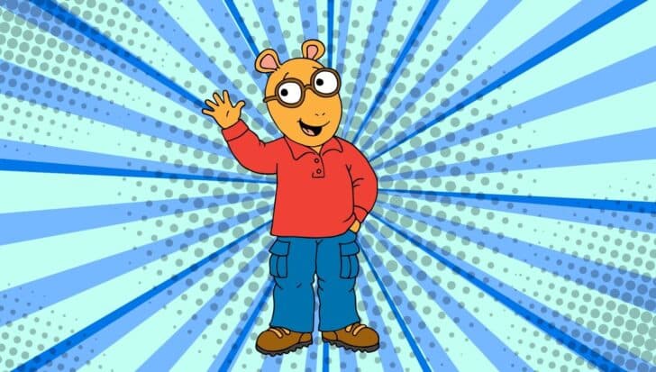 Cartoon character Arthur, an aardvark, wearing glasses and a red sweater, waving against a blue patterned background