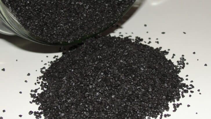 Black powder granules spilled from a container, related to fireworks composition