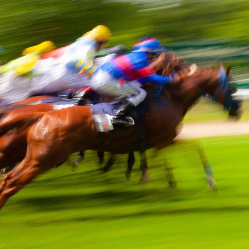 Blurred image of jockeys riding horses in a horse race