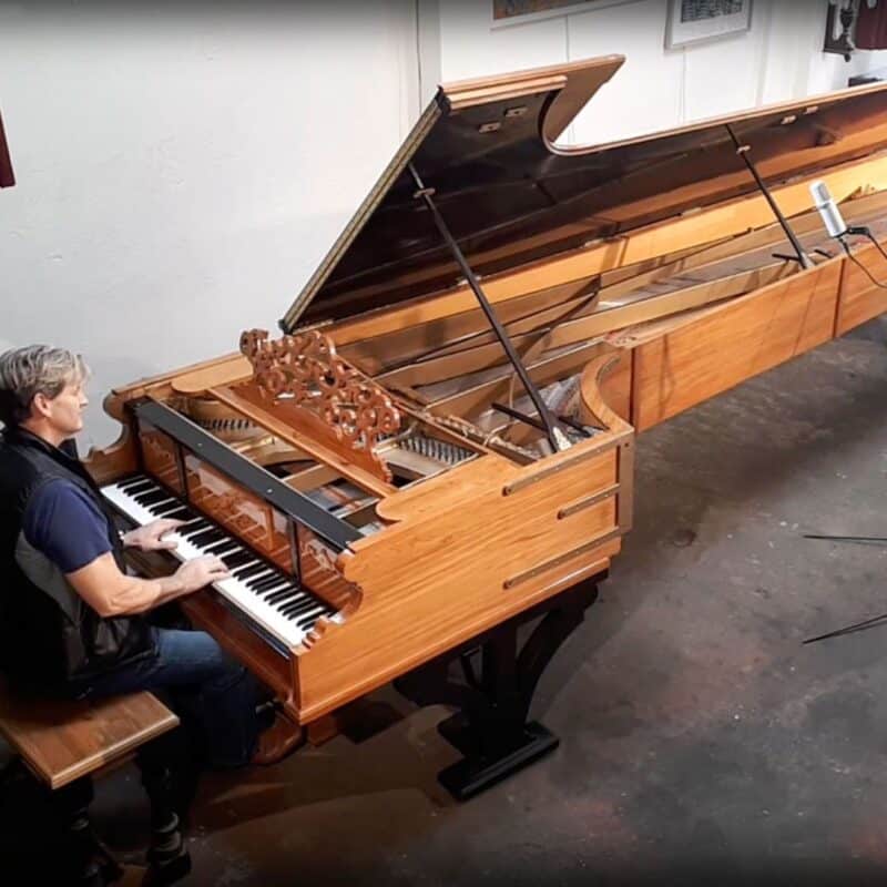 A person playing the world’s largest piano in a spacious room