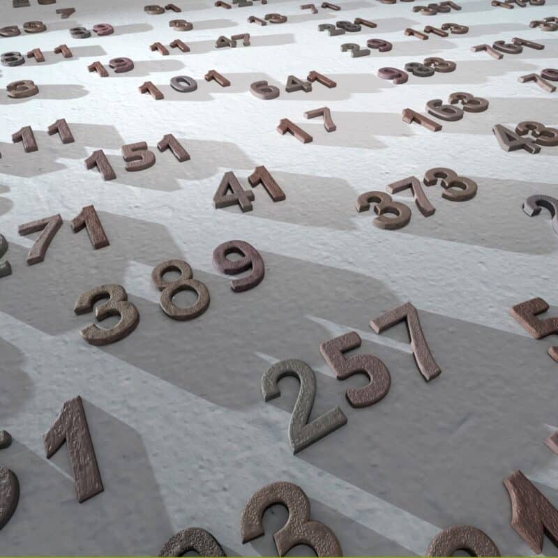 Numerous three-dimensional numbers scattered on a textured surface, casting shadows