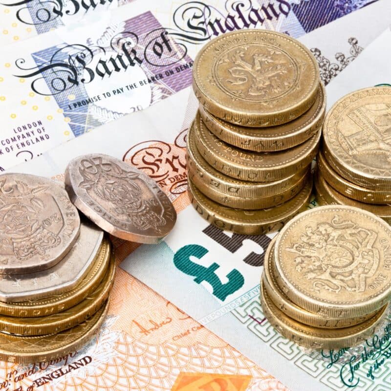 Stacks of British pound coins and banknotes