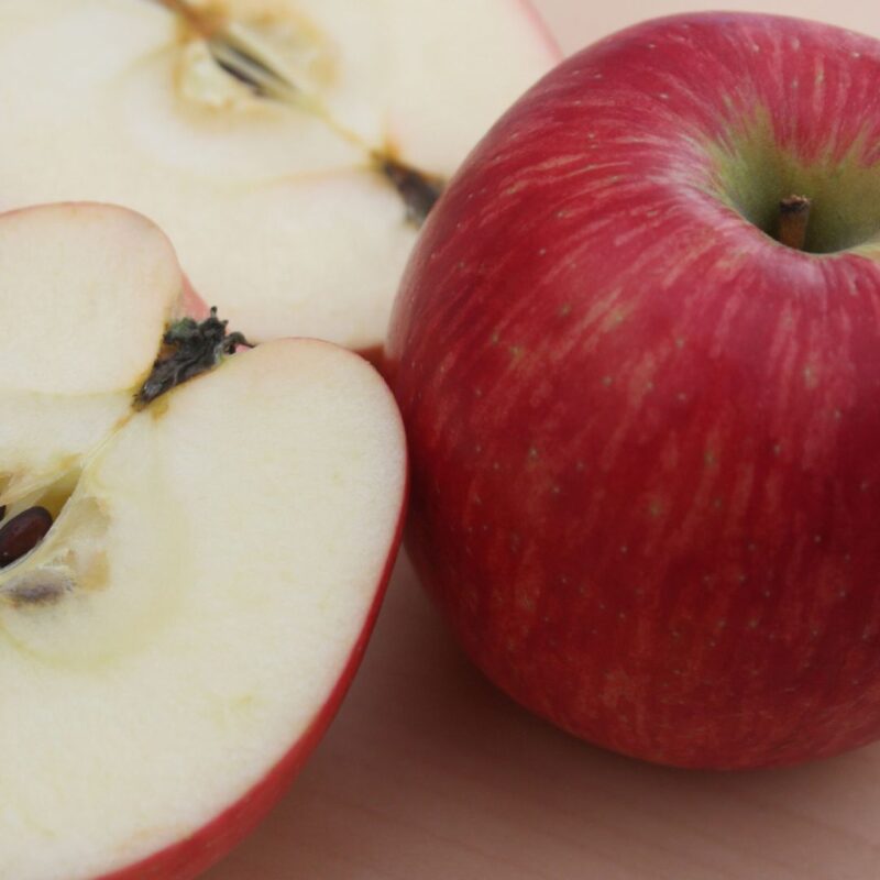 Whole red apple and a sliced apple showing seeds